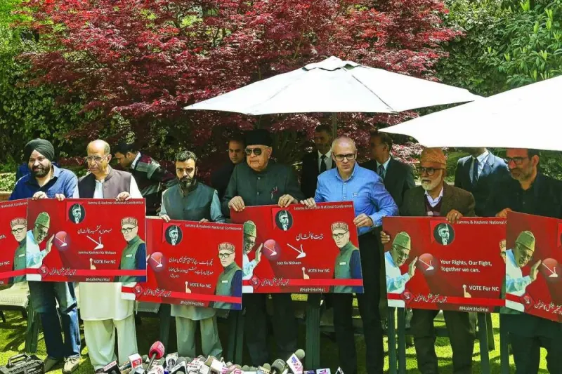 Former Jammu and Kashmir chief minister and vice-president of the National Conference (NC) party Omar Abdullah (third right), NC president Farooq Abdullah (centre) along with party leaders pose for pictures with election posters during a press conference in Srinagar on Friday ahead of India’s upcoming general elections.