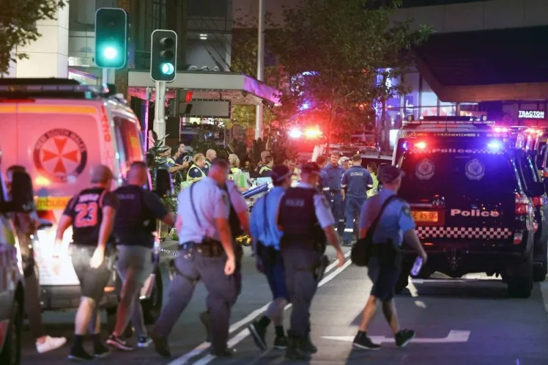 Police (foreground) and paramedics with stretchers (background C) are seen outside the Westfield Bondi Junction shopping mall after a stabbing incident in Sydney on Saturday. AFP