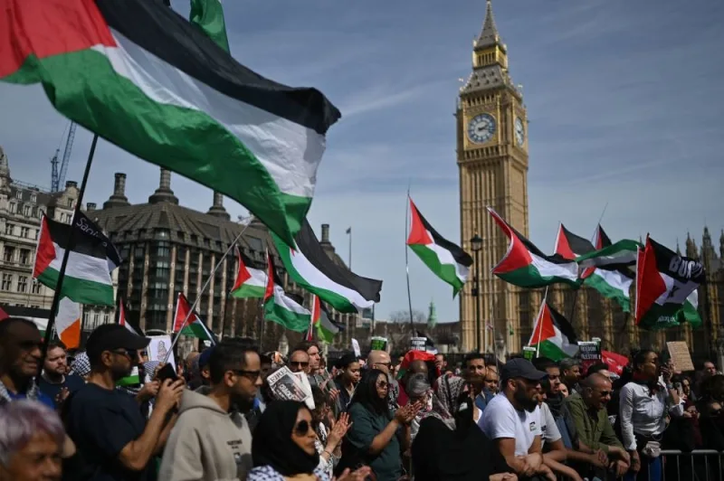 Pro-Palestinian activists and supporters wave flags and hold placards as during a protest march near the the Houses of Parliament in central London, during a National Day of Action calling for a ceasefire in the Israel-Hamas war. AFP