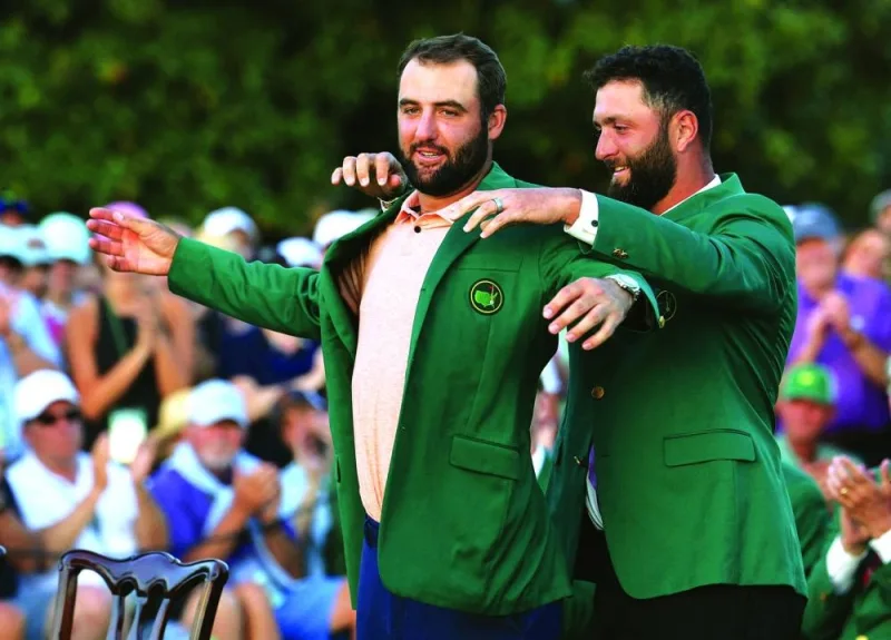 Scottie Scheffler of the US is presented with the green jacket by last year&#039;s winner Spain&#039;s Jon Rahm after winning The Masters. (Reuters)