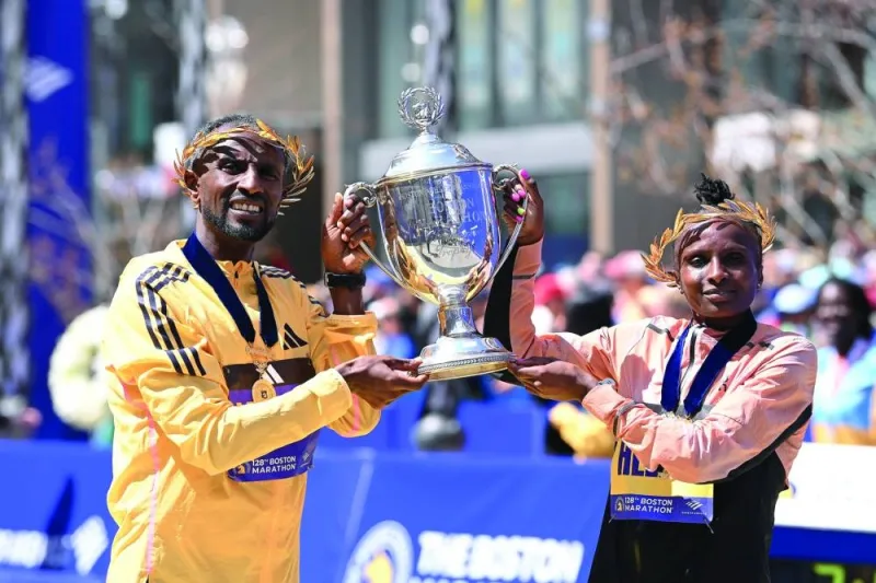 
Sisay Lemma of Ethiopia and Hellen Obiri of Kenya pose at the finish line with the winner’s trophy at the 2024 Boston Marathon. (USA TODAY Sports) 