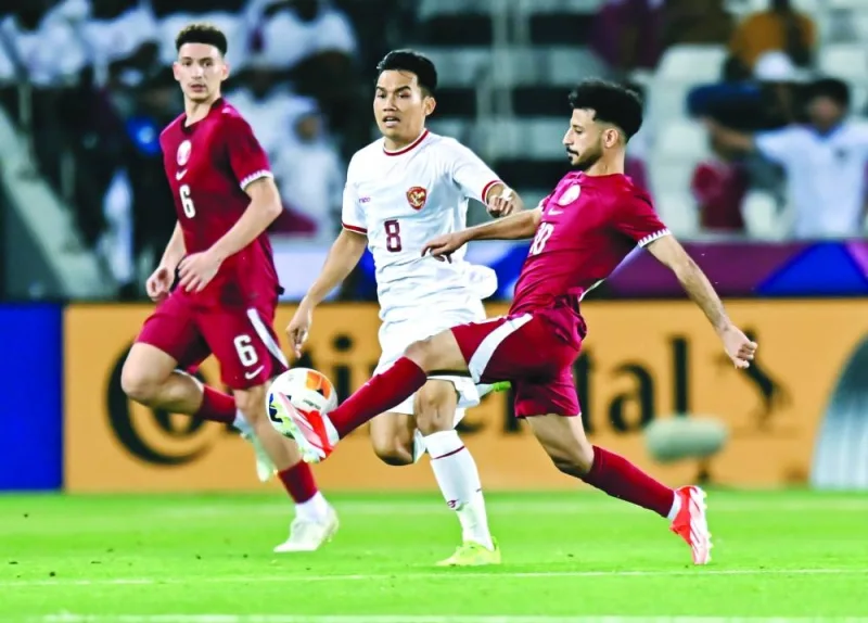 
Qatar’s Khaled Ali (right) vying for the ball with an Indonesia player. 