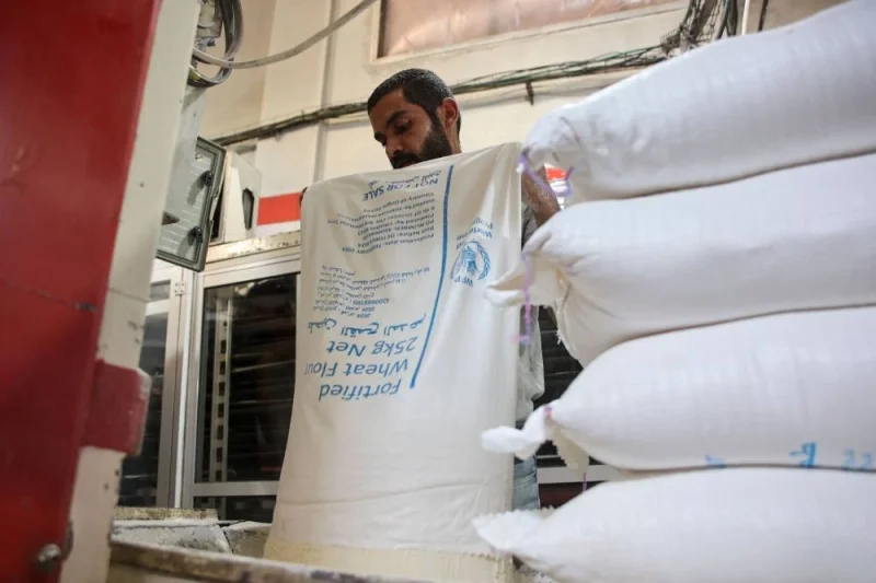 A Palestinian worker empties sacks of flour donated by the World Food Programme at a bakery in Gaza City on Sunday. AFP