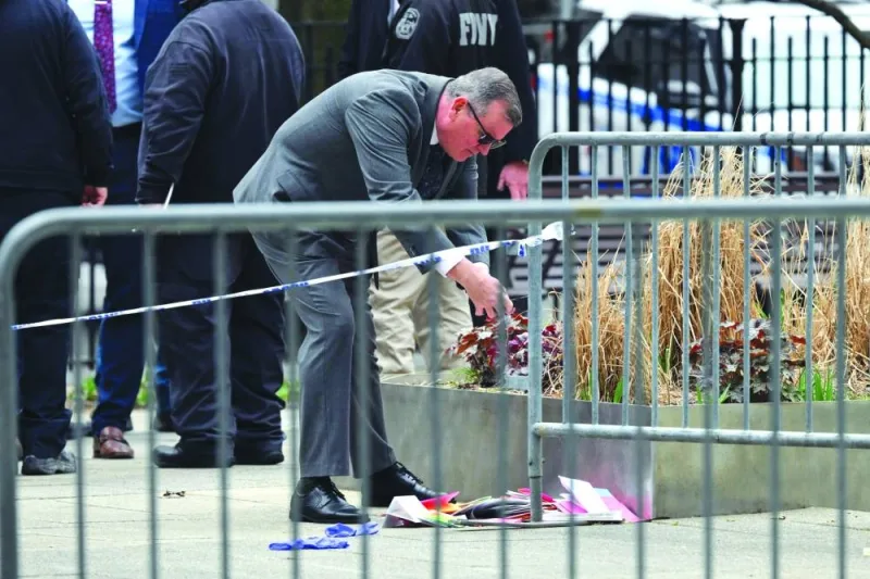 
An Investigator take pictures of pamphlets thrown by a man after he reportedly set himself on fire, at the park across from Manhattan Criminal Court in New York City. 