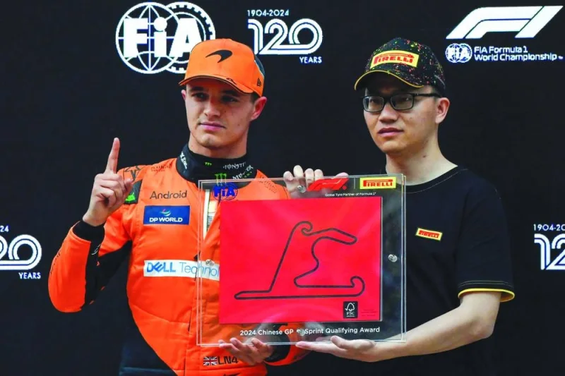 Lando Norris (left) receives an award for getting first position in the sprint qualifying session in Shanghai on Friday. (AFP)