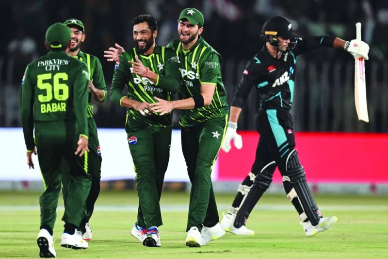 Pakistan’s Mohamed Amir (third from right) celebrates with teammates after taking the wicket of New Zealand’s Tim Robinson (right) during the second Twenty20 match at the Rawalpindi Cricket Stadium in Rawalpindi on Saturday. (AFP)