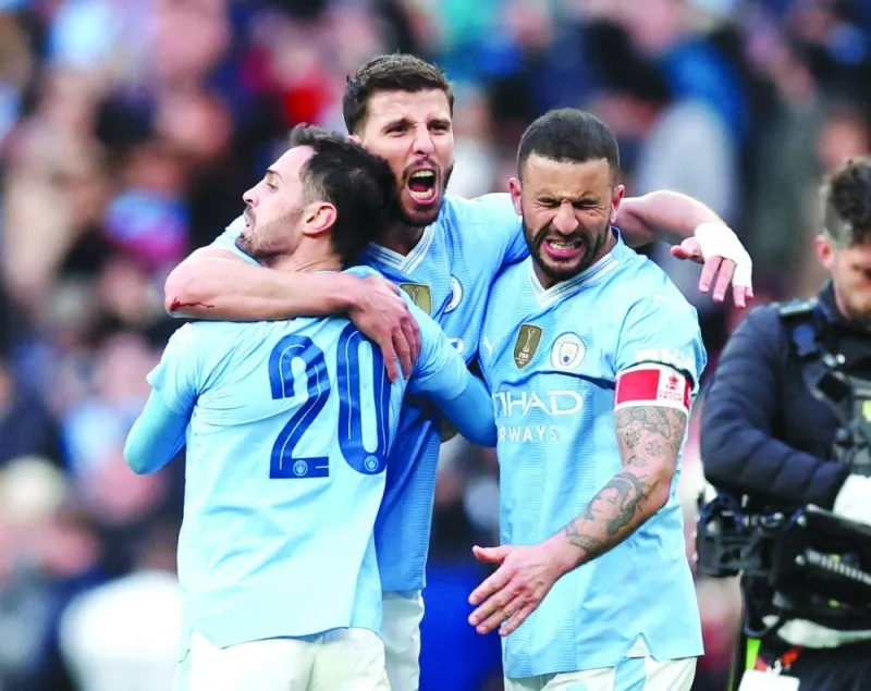 Manchester City’s Bernardo Silva, Kyle Walker and Ruben Dias celebrate after beating Chelsea in the FA Cup semi-final in London on Saturday.