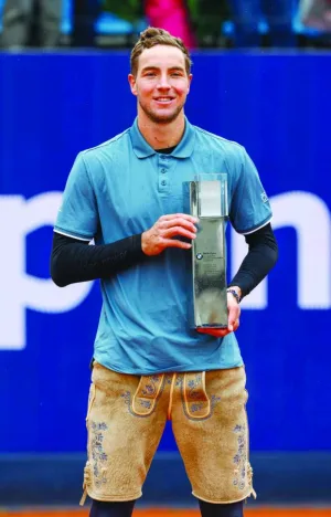 Germany&#039;s Jan-Lennard Struff wears traditional "Lederhosen" (leather trousers) dress and presents his trophy after defeating Taylor Fritz from the US (not in picture) in the final of the ATP Tour tennis tournament in Munich, southern Germany, yesterday. (AFP)