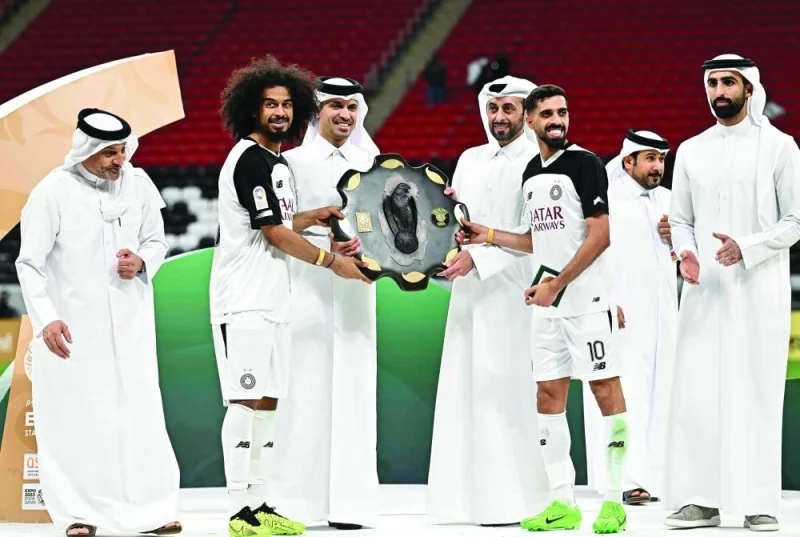 Al Sadd captain Hassan al-Haydos and forward Akram Afif receive QSL Shield from QFA president Jassim Rashid al-Buenain as QSL CEO Hani Taleb Ballan looks on on Wednesday. PICTURES: Noushad Thekkayil