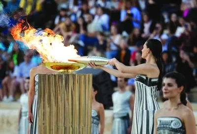 Greek actress Mary Mina, playing the role of High Priestess, holds the Olympic torch by the cauldron during the Handover Ceremony for the Paris 2024 Olympics at Panathenaic Stadium, Athens, Greece, on Friday. (Reuters)