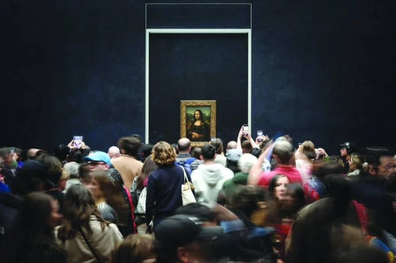 Visitors take picture of the Mona Lisa by Italian artist Leonardo Da Vinci, on display in a gallery at the Louvre in Paris.