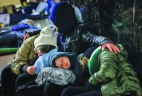 
A family sleeps while taking shelter inside a metro station in Kyiv during a Russian missile strike. 