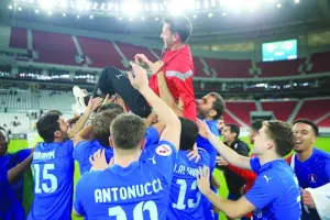 Al Shahania players celebrate with Spanish coach Alvaro Mejia after their 2023-2024 season relegation play-off win against Al Markhiya at Al Thumama Stadium in Doha yesterday.