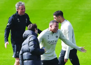 Paris Saint-Germain’s forward Kylian Mbappe (centre) reacts next to head coach Luis Enrique (left) and defender Achraf Hakimi during a training session yesterday, on the eve of the Champions League semi-final second match against Borussia Dortmund. (AFP)