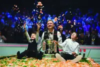 
England’s Kyren Wilson and his sons Bailey (left) and Finley pose with the trophy after victory over Wales’ Jak Jones on day two of their World Championship Snooker final at The Crucible in Sheffield, northern England, on Monday night. Wilson won the final 18-14. (AFP) 