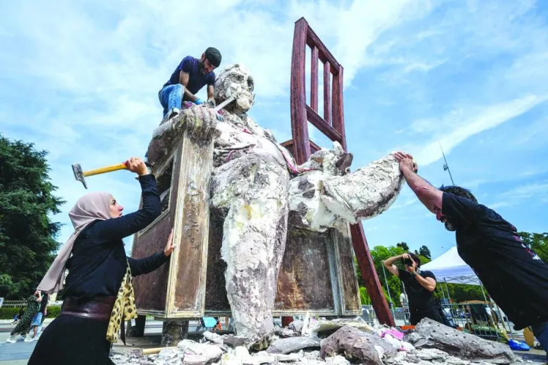 Syrian exiled sculptor Khaled Dawwa (top) with the help of relatives of people who disappeared in Syria, destroy his giant art work The King of Holes, depicting a potentate with a massive body, as part of a protest on the occasion of International Day of the Disappeared, in front of the United Nations offices in Geneva. – AFP Syrian exiled sculptor Khaled Dawwa (top) with the help of relatives of people who disappeared in Syria, destroy his giant art work The King of Holes, depicting a potentate with a massive body, as part of a protest on the occasion of International Day of the Disappeared, in front of the United Nations offices in Geneva. – AFP