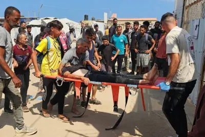 يحمل الفلسطينيون رجلاً مصابًا بجروح ، حيث كان يصطف في طوابير للمساعدة ، باتجاه مستشفى في رفه ، في قطاع غزة الجنوبي يوم الاثنين. AFP يحمل الفلسطينيون رجلاً مصابًا بجروح ، حيث كان يصطف في طوابير للمساعدة ، باتجاه مستشفى في رفه ، في قطاع غزة الجنوبي يوم الاثنين. AFP