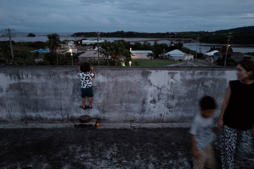 Aoi Suzuki and her two sons try to catch a glimpse of the dwindling sunset from a rooftop in Taketomi on Iriomote Island
