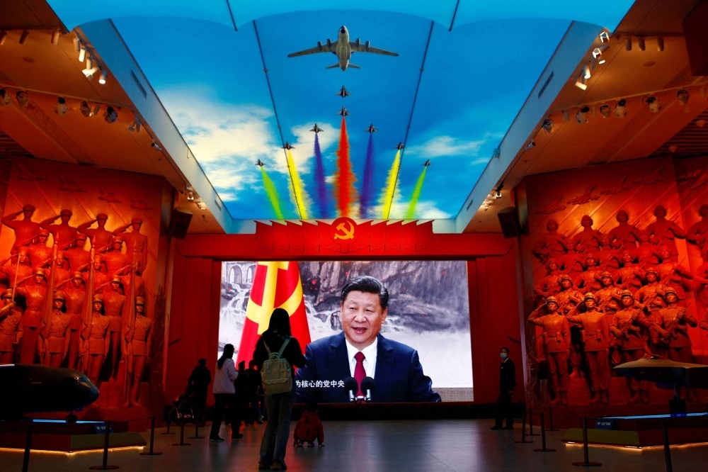Visitors stand in front of a giant screen displaying Chinese leader Xi Jinping next to a flag of the Communist Party of China, at the Military Museum of the Chinese People's Revolution in Beijing last October.