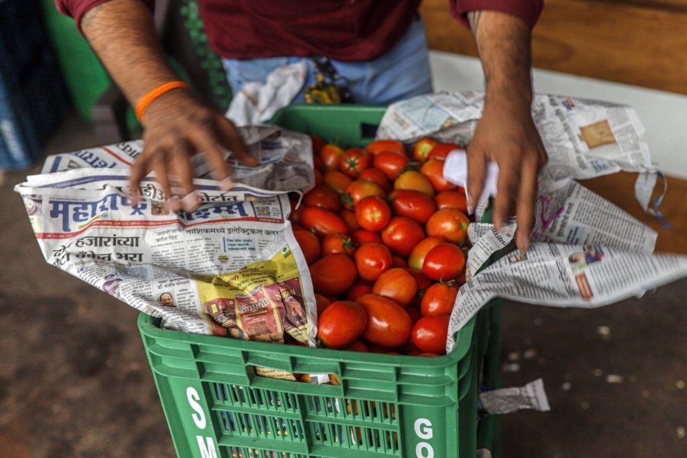 A vendor arranges tomatoes at a wholesale vegetable market in Ahmedabad, India, on July 19.