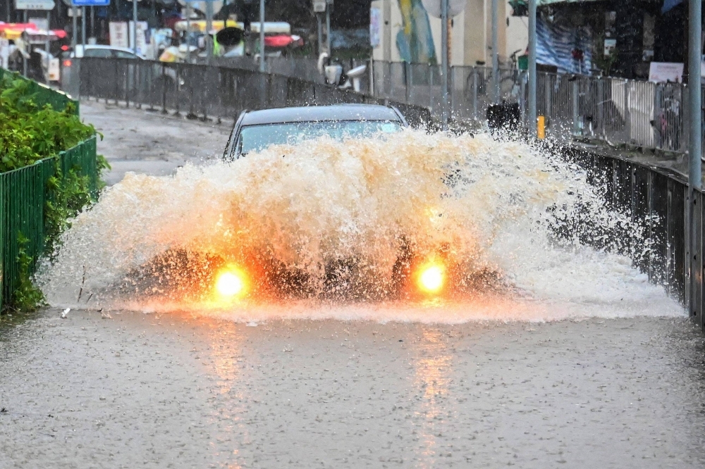 A car drives through floodwaters on Lantau Island in Hong Kong on Friday.