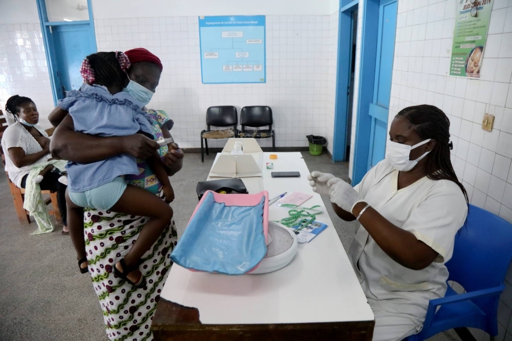 A nurse prepares to take care of a child with malaria at a hospital in Abidjan, Ivory Coast.