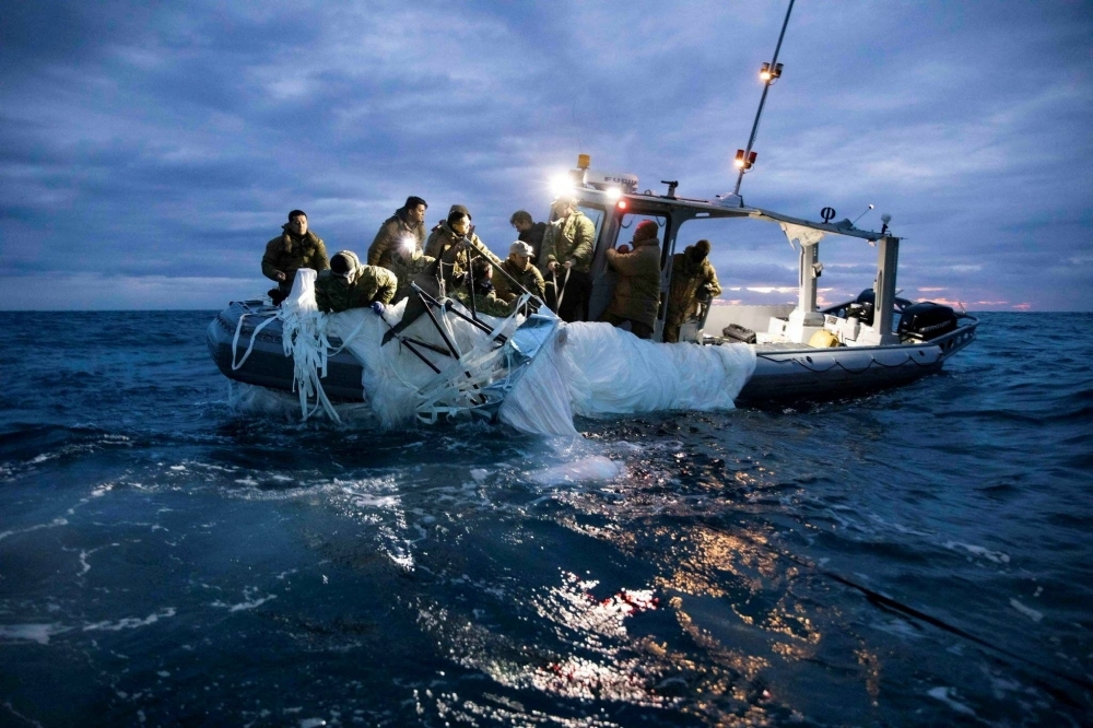 U.S. Navy sailors recover a suspected Chinese high-altitude surveillance balloon that was downed by the United States over U.S. territorial waters off the coast of Myrtle Beach, South Carolina, in February. 