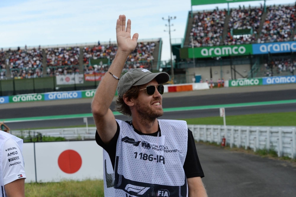 引退したフォーミュラ1チャンピオンのSebastian Vettelは、土曜日に危険信号が中断されている間、トラックでファンに手を振っています。