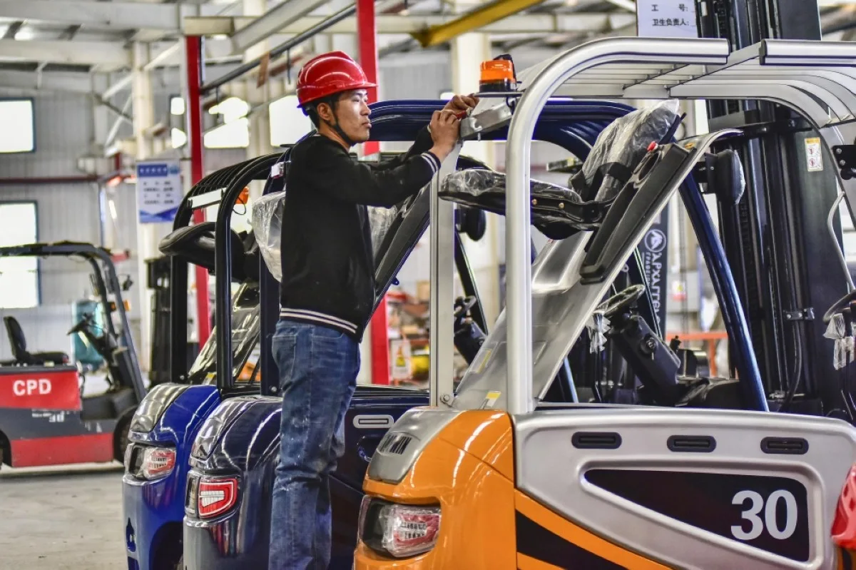 QINGZHOU, China: This photo taken on October 27, 2023 shows a worker producing forklifts at a factory in Qingzhou, in China's eastern Shandong province. – AFP