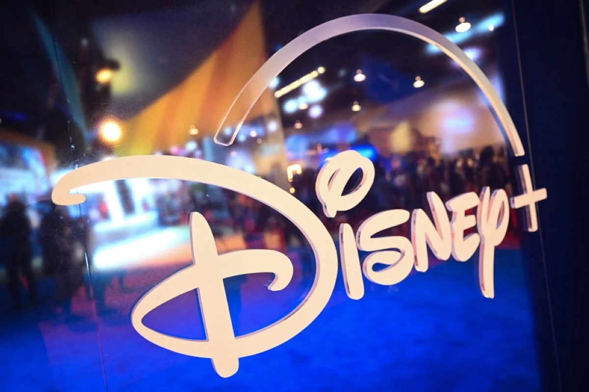 ANAHEIM: (FILES) Fans are reflected in the Disney logo during the Walt Disney D23 Expo in Anaheim, California, on September 9, 2022. Disney said on November 8, 2023, its streaming service had attracted seven million new subscribers, reversing several quarters of decline that had raised doubts about its rivalry with industry leader Netflix. – AFP