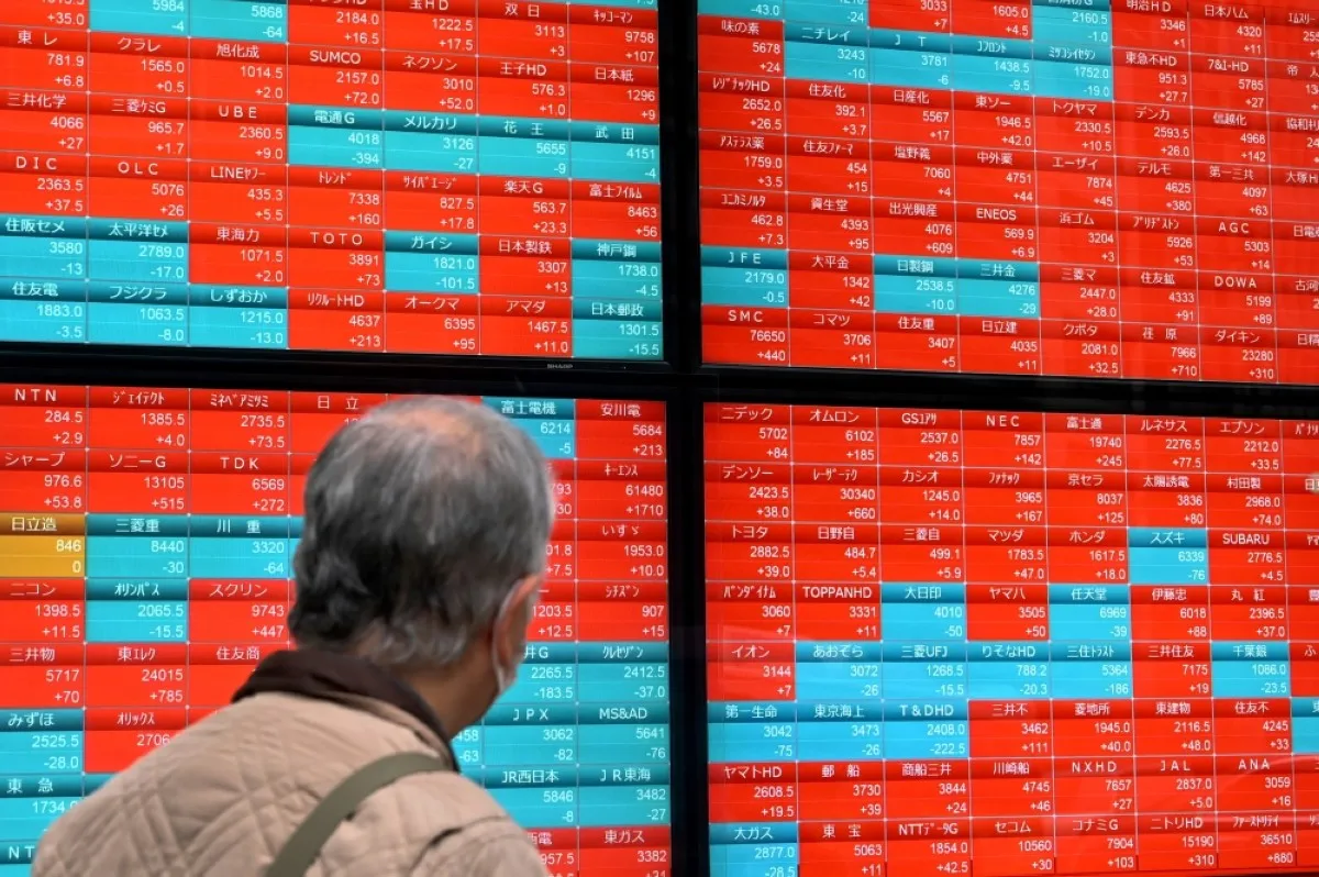 TOKYO: A man looks at an electronic board displaying stock prices of each company listed on the Tokyo Stock Exchange along a street in Tokyo. – AFP