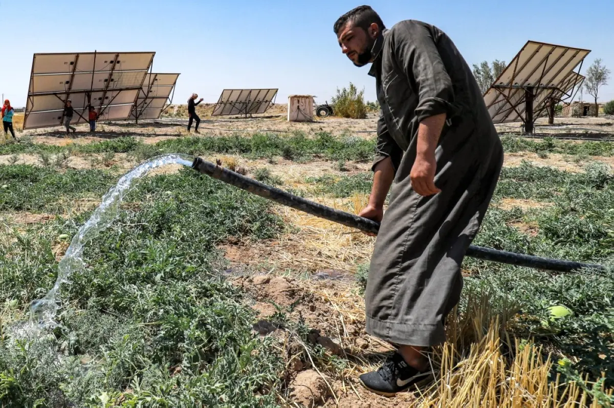 HASAKEH, Syria: Syrian farmer Mohamed Ali Al-Hussein, 22, waters a watermelon patch with a hose near solar panels used to power field irrigation at a farm on the outskirts of Syria's northeastern city of Hasakeh, on September 24, 2023. -- AFP