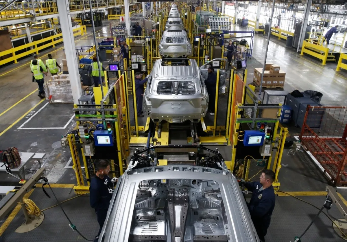 Workers assemble cars at the newly renovated assembly plant in Chicago. -- AFP