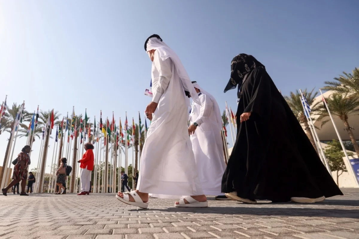 DUBAI: Participants walk past flags of attending countries at the COP28 United Nations climate talks in Dubai on December 4, 2023.-- AFP
