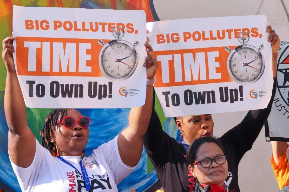 Environmental activists display placards during a demonstration at the venue of the COP28 United Nations climate summit in Dubai on December 5, 2023.--AFP