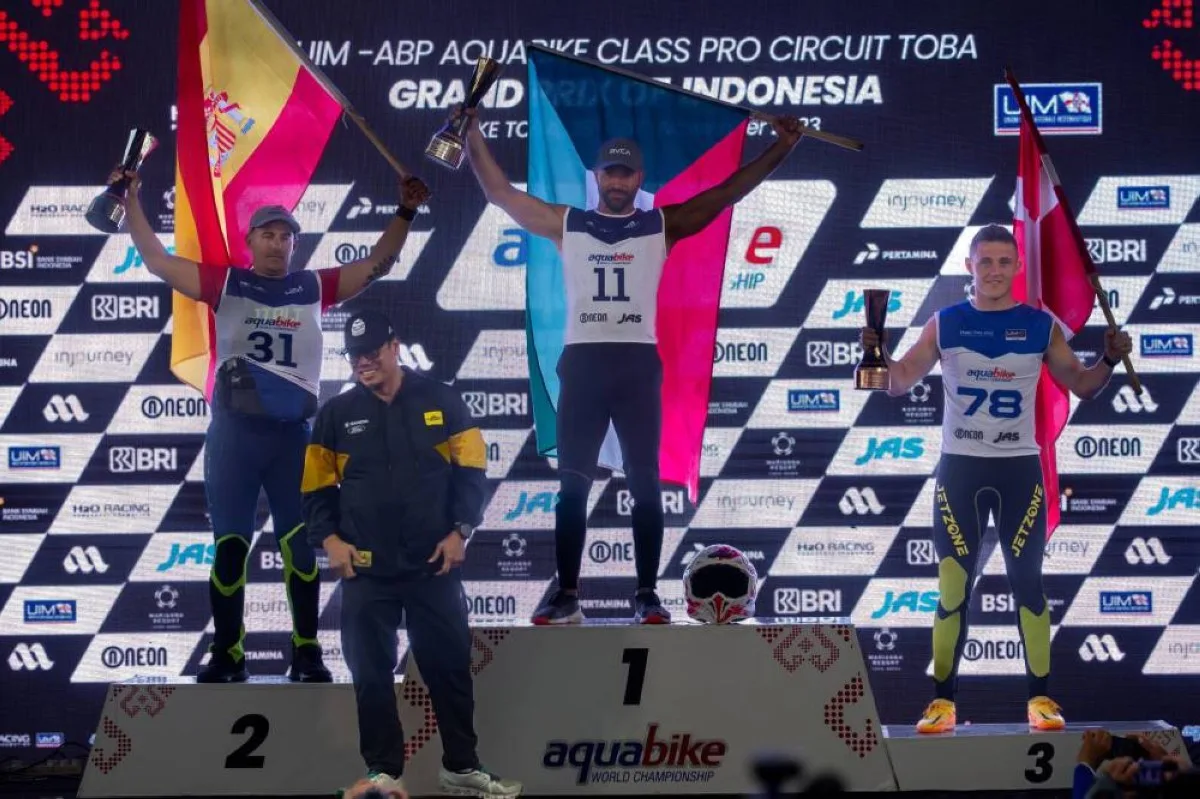 Al Abdulrazzaq raising the Kuwaiti flag on the first-place podium.