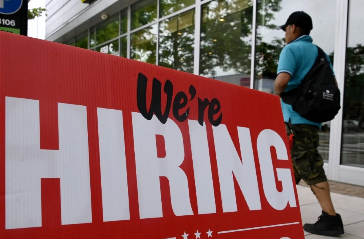 ARLINGTON: A man walks past a "now hiring" sign posted outside of a restaurant in Arlington, Virginia, on June 3, 2022. -- AFP
