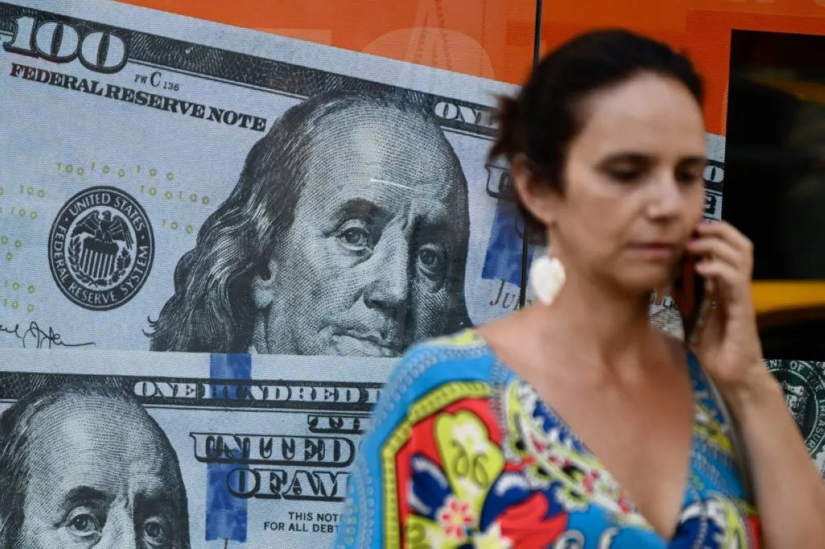 BUENOS AIRES: A woman walks past an image of one hundred US dollar notes in Buenos Aires on December 12, 2023. -- AFP