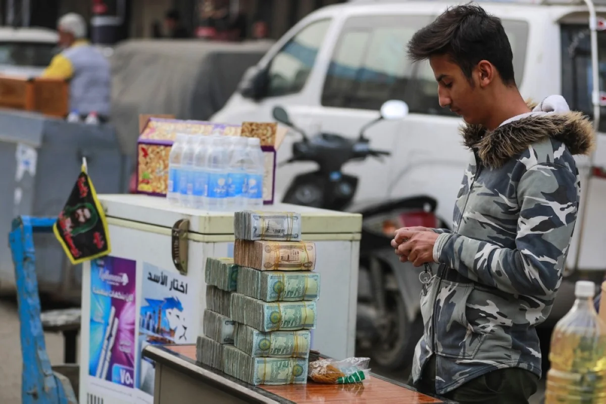 BAGHDAD: A currency exchange agent mans his kiosk on Al-Kifah Street in central Baghdad. --AFP 

