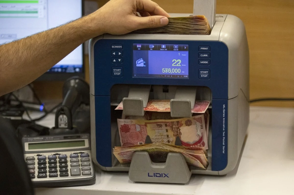 BASRA: A currency exchange agent counts Iraqi dnars at his company in Iraq's southern city of Basra. --AFP