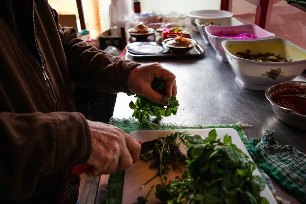 KAFR KILA, Lebanon: Lebanese Hussein Murtada prepares food in his restaurant in the village of Kfar Kila near the border with Zionists. In Kfar Kila, nestled among olive trees, some houses have been completely destroyed, and the sound of nearby bombardment rumbles through the air. - AFP