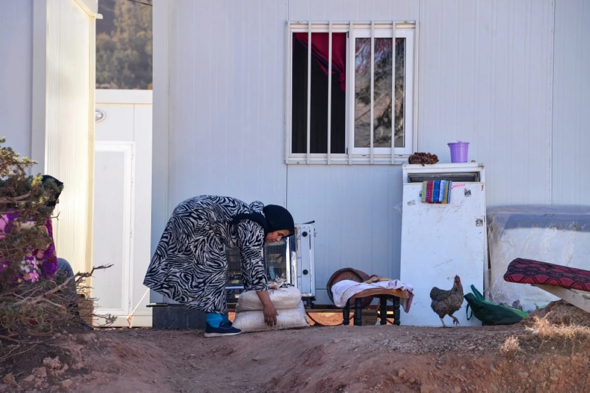 OUIRGANE, Morocco: A displaced Moroccan woman carries bags in a temporary camp in the hamlet of Imzilne in the Ouirgane commune, some 60 kilometers south of Marrakesh. – AFP