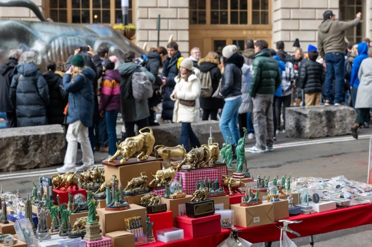 NEW YORK: People walk through the Financial District by the New York Stock Exchange (NYSE) on the last day of trading for the year on December 29, 2023 in New York City. -- AFP