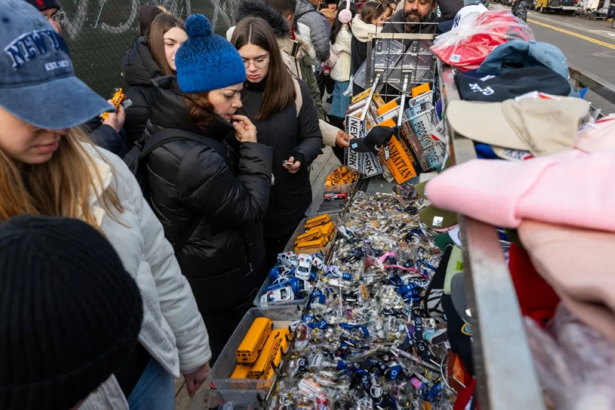 NEW YORK: Tourists browse through vendor stalls along a street after they were forced to move from the Brooklyn Bridge on the first day that a new law outlawing vendors on the bridge went into effect on January 03, 2024 in New York City. The new law is designed to clear the heavily packed pedestrian walkway on the bridge, one of Manhattan’s top tourist attractions. – AFP