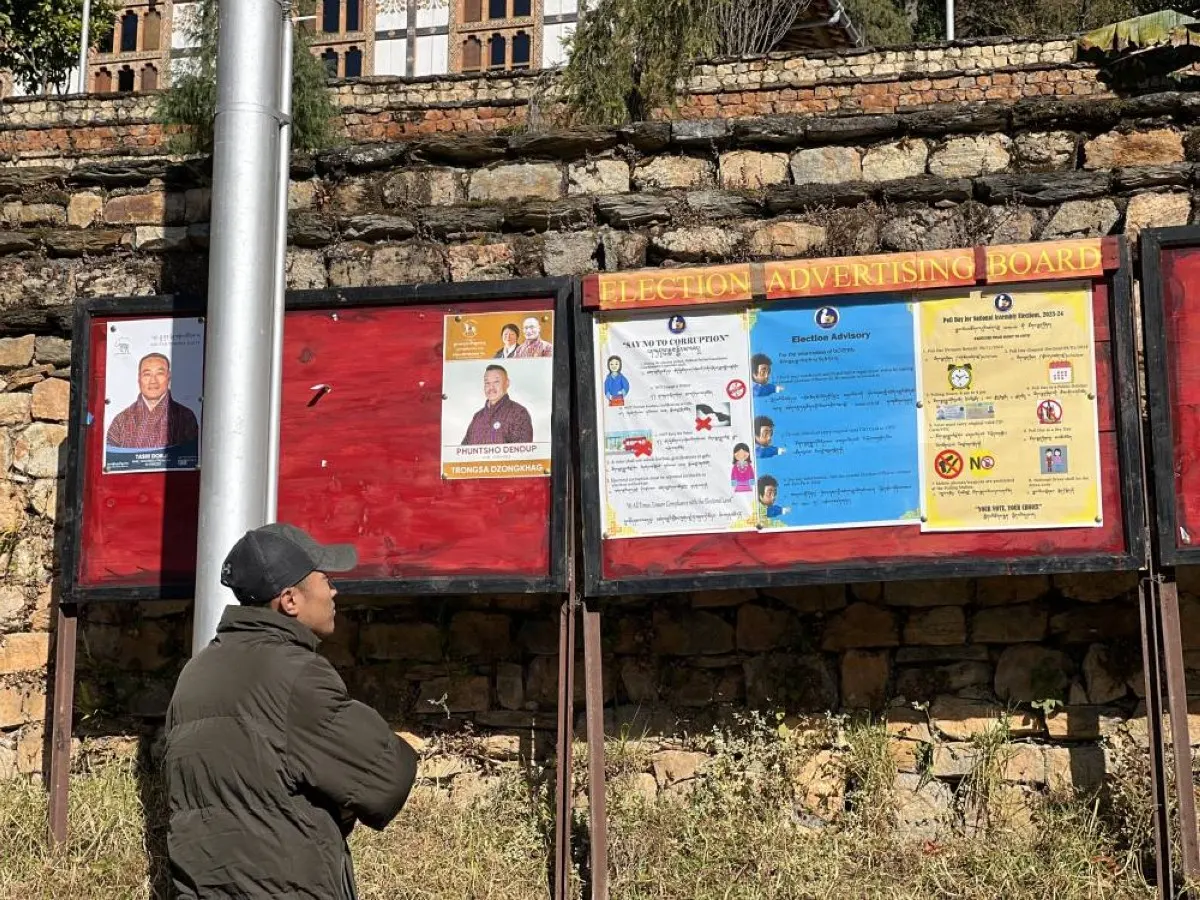 TRONGSA, Bhutan: In this picture taken on December 31, 2023, a man reads an election board ahead of the upcoming parliamentary elections in Trongsa. -- AFP