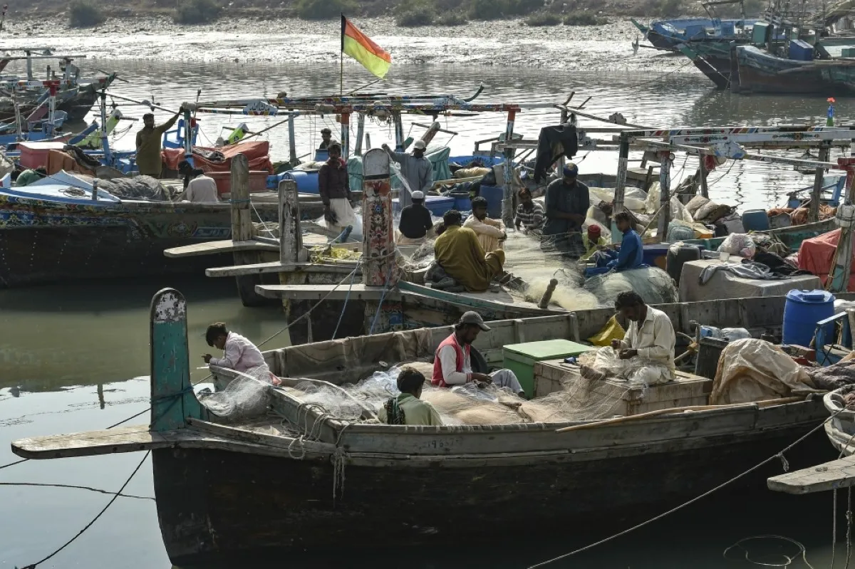 KARACHI: Fishermen repair their fishing nets on the boats at Ibrahim Haidery fishing village on the outskirts of Karachi, on January 9, 2024. - AFP