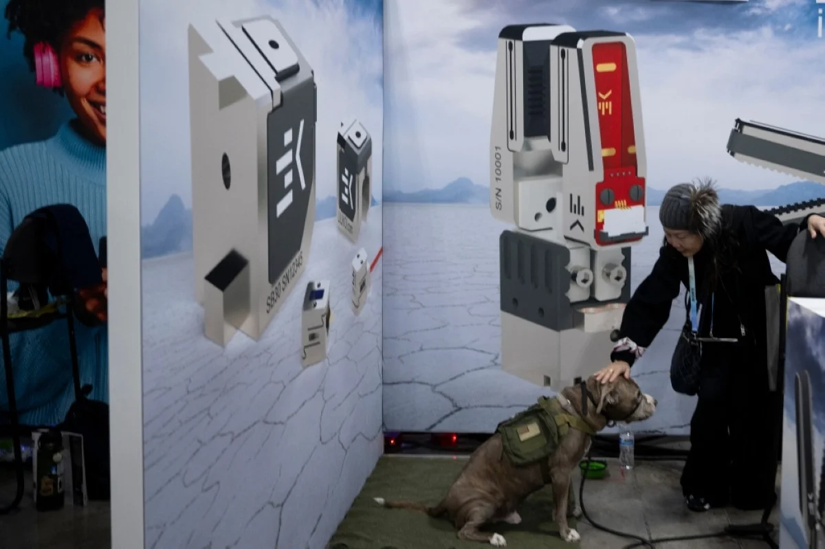 A woman pets a dog staying with her in a booth at the Eureka Park exhibition in the Venetian Expo Center during the Consumer Electronics Show (CES) in Las Vegas. --AFP