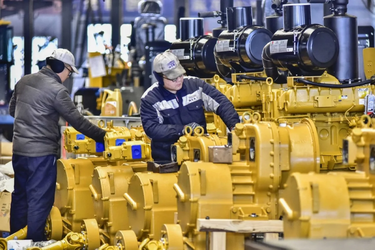 QINGZHOU, China: Employees work on an assembly line producing wheel loaders at a factory in Qingzhou, in eastern China's Shandong province on January 17, 2024. – AFP