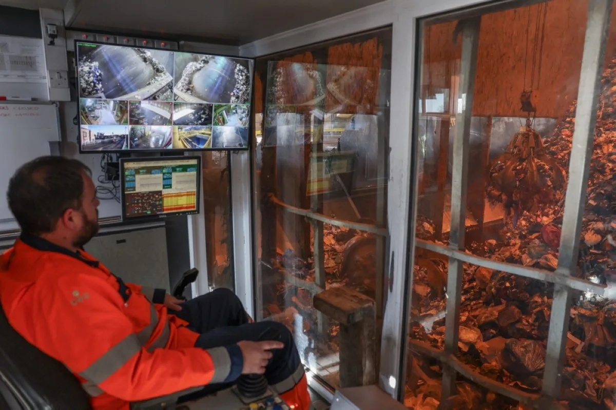LONDON: A waste refuse bunker operator moves a claw to collect waste before being incinerated at a Veolia waste management plant, in south London. – AFP