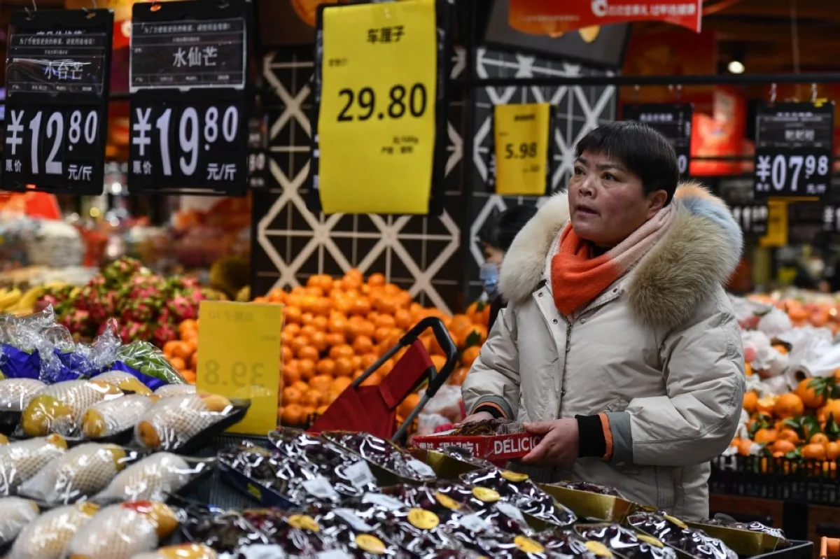 FUYANG, China: A customer shops for vegetables and fruit at a supermarket in Fuyang, in eastern China's Anhui province on February 8, 2024. -- AFP